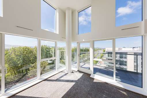 a living room with large windows and a view of the city