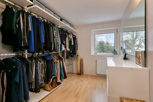 a closet with a window and a rack of clothes