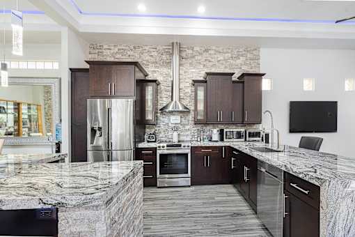 a large kitchen with granite counter tops and stainless steel appliances