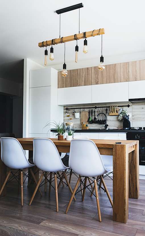 a kitchen with white cabinets and a wooden table and chairs