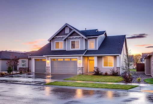 A house with a grey roof and a garage is shown.