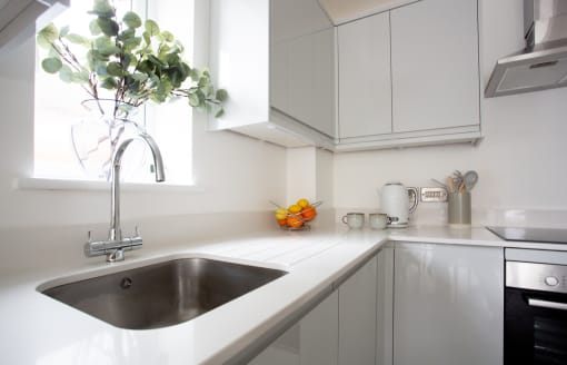 a white kitchen with a sink and a window