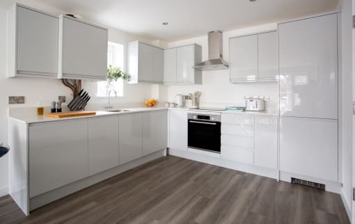 a white kitchen with white cabinets and a wood floor