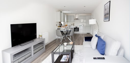 a living room with a white couch and a table with a television