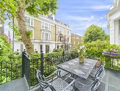 a patio with a table and chairs and a tree