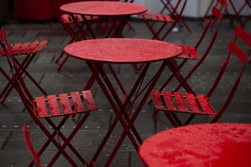 a group of red tables and chairs in the rain