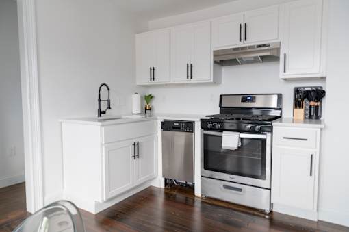 a kitchen with white cabinets and stainless steel appliances