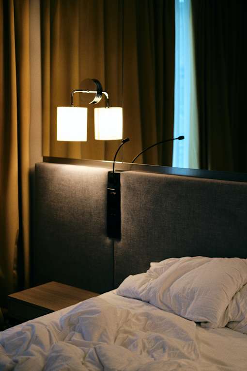 a hotel room with a bed and two lamps