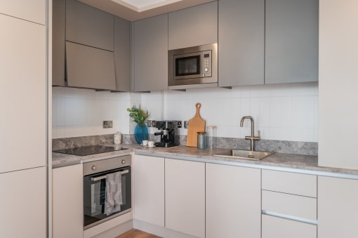 a kitchen with white cabinets and a sink and a microwave