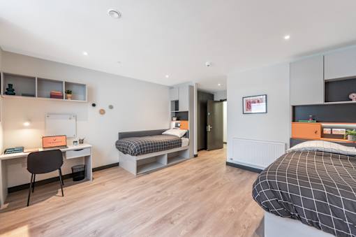 a bedroom with a bed and a desk in a room