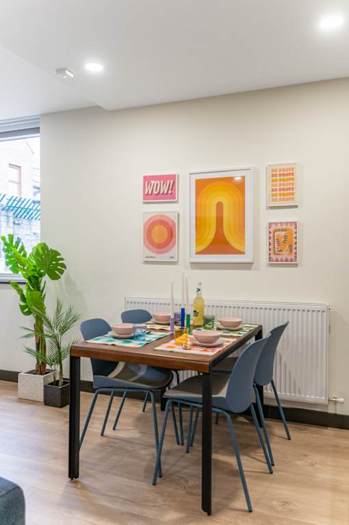 a dining room with a table and chairs and paintings on the wall