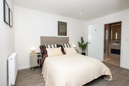 A bedroom with a large bed and a radiator on the wall.