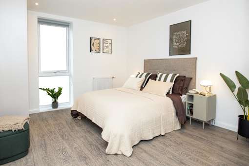 A bedroom with a large bed and a window.