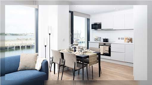 A modern dining area with a table set for two and a view of the water.