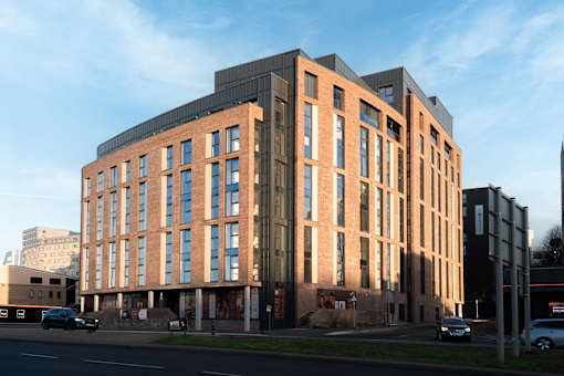 A modern building with a combination of brick and darker colored panels.