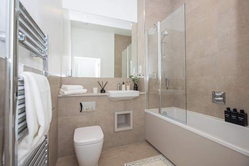 A bathroom with a toilet, sink, and shower.