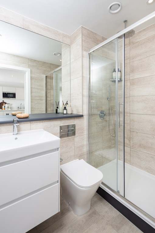 A white toilet sits next to a sink in a modern bathroom.