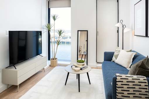 A living room with a blue couch and a white coffee table.