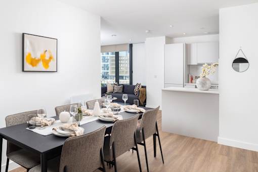 A dining room with a table set for a meal.