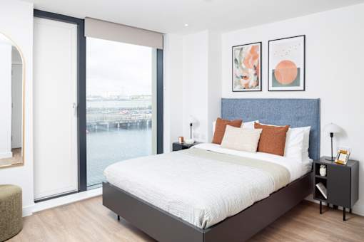 A bedroom with a large bed and a view of the city.