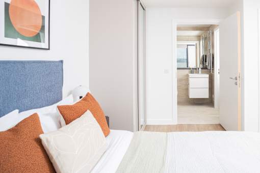A bedroom with a bed and a painting on the wall.