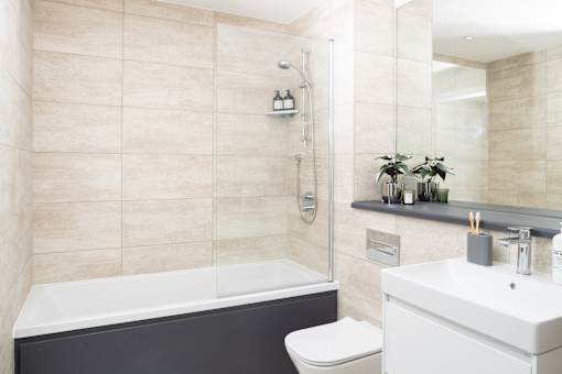 A bathroom with a white toilet and a black tub.