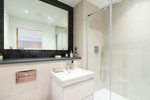 A white sink sits under a mirror in a bathroom.
