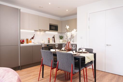 A modern kitchen with a dining table set for two.