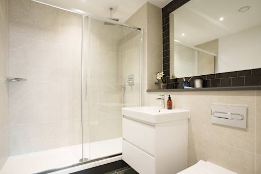 A white sink sits under a mirror in a modern bathroom.