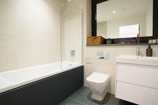 A white toilet sits next to a white sink in a bathroom.
