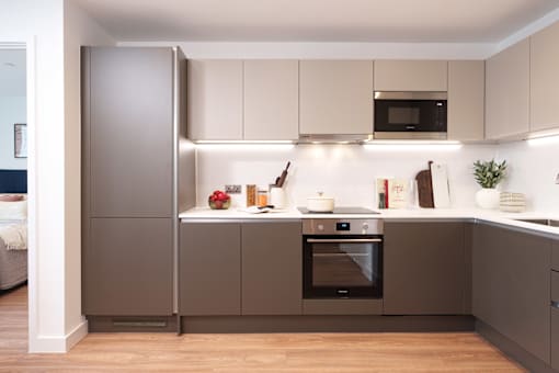 A modern kitchen with a refrigerator, oven, and microwave.
