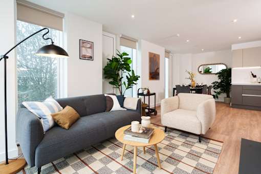 A living room with a grey couch, a white armchair, and a coffee table.