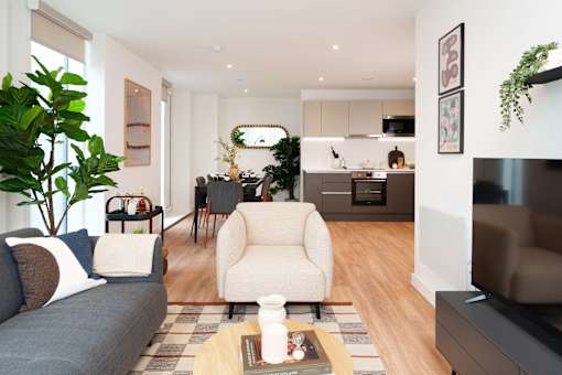A living room with a grey couch and a white chair.