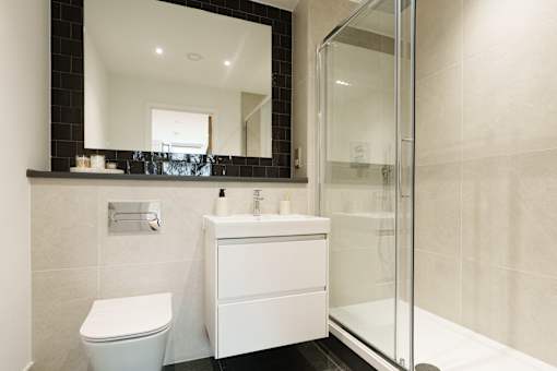 A white sink and toilet in a modern bathroom.