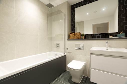 A white toilet sits next to a bathtub in a bathroom.