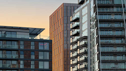 Two buildings with balconies and windows are shown in the image.