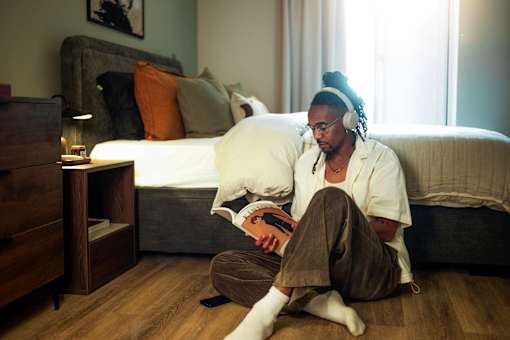 A man is sitting on the floor at Fairfax Apartments, Manchester