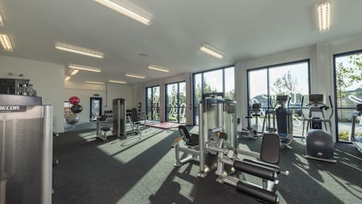 the gym is equipped with state of the art equipment and windows at The Keel Apartments, Liverpool, L3 4GE