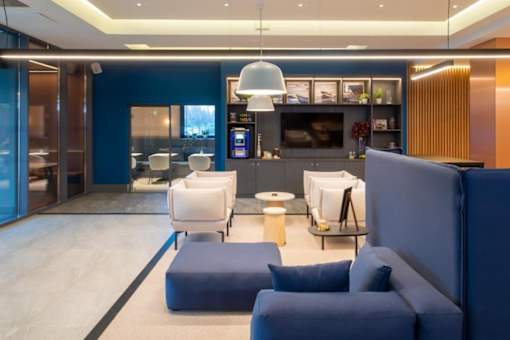 a living room with blue chairs and a white rug at The Keel Apartments, Liverpool
