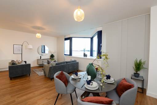 a living room with white walls and a table and chairs at The Keel Apartments, Liverpool, L3 4GE