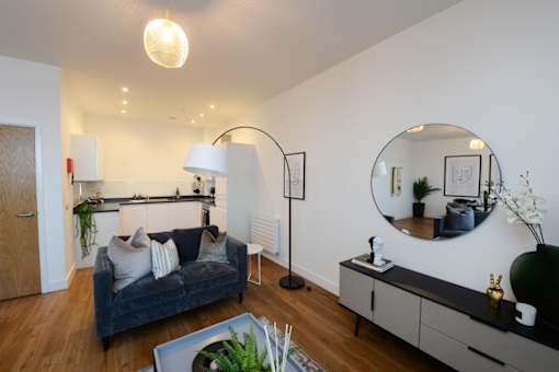 a living room with a couch and a mirror at The Keel Apartments, Liverpool, L3 4GE