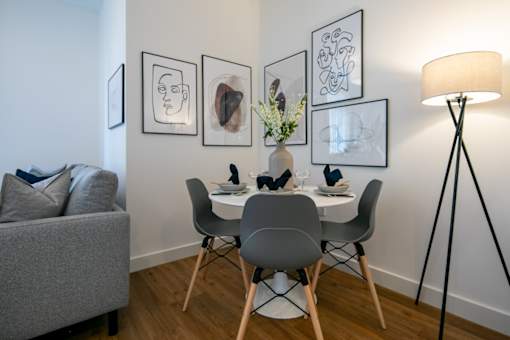 a dining room with a table and chairs and a lamp at The Keel Apartments, Liverpool, L3 4GE