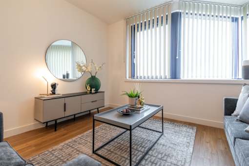 a living room with a couch and a table and a mirror at The Keel Apartments, Liverpool, L3 4GE