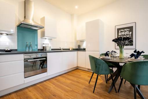 a kitchen and dining area with a table and chairs at The Keel Apartments, Liverpool, L3 4GE