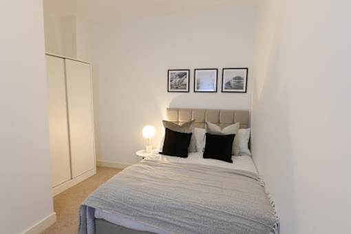 a bedroom with a bed and three pictures on the wall at The Keel Apartments, Liverpool