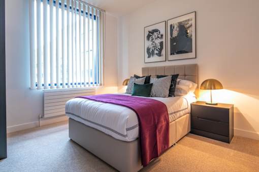 a bedroom with a bed and a window at The Keel Apartments, Liverpool