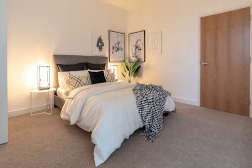 a bedroom with a bed and a wooden closet at The Keel Apartments, Liverpool, L3 4GE