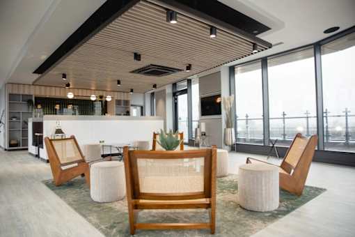a large lobby with chairs and a table and a large window at Vox Apartments, Manchester, M15 4YD
