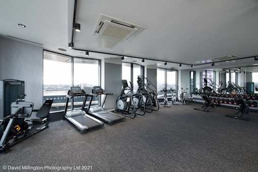 spacious gym with floor to ceiling windows and cardio equipment in a building at Vox Apartments, Manchester
