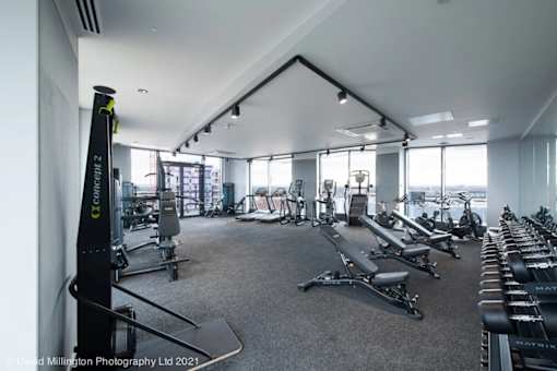 spacious gym with cardio equipment and views of the city at Vox Apartments, Manchester, M15 4YD